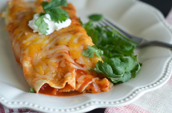 enchilada made in the air fryer with sour cream and a fork on the side